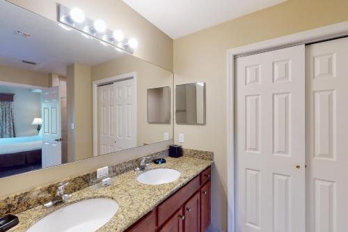 een badkamer met 2 wastafels en een grote spiegel bij Worldquest Wonderland in Orlando