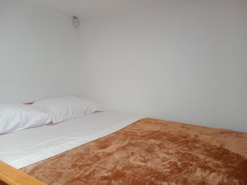 a bedroom with a bed with white sheets and a wooden floor at Dream View in Pico in Criação Velha