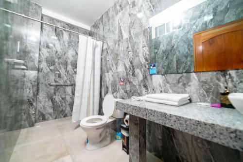 a bathroom with a toilet and a sink and a shower at Patty House Galapagos in Puerto Ayora