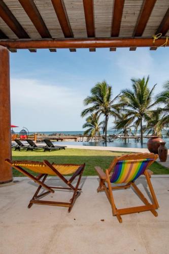 a pair of chairs and a hammock on a patio at Villa Don Luis Troncones in Joluta