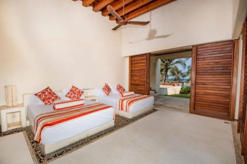 two beds in a room with sliding glass doors at Casa Don Luis Lujosa casa frente a la playa 