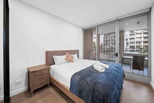 a bedroom with a bed and a large window at Nice Olympic park next to stadium 2b2b1p1study in Sydney