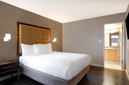 a bedroom with a large bed and a bathroom at Days Inn by Wyndham Victoria Uptown in Victoria