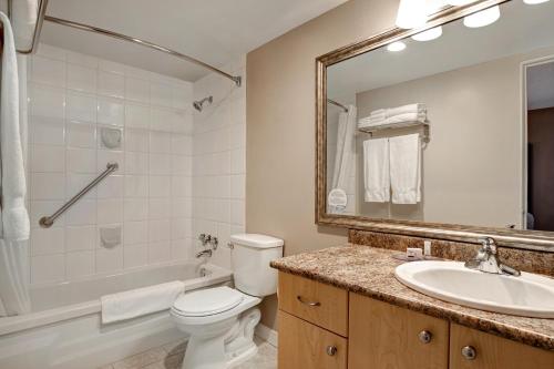 a bathroom with a sink toilet and a mirror at Days Inn by Wyndham Victoria Uptown in Victoria