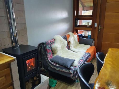 a living room with a couch and a stove at Rancho 4 Corações in Urubici