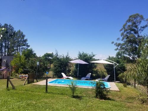 a swimming pool with two chairs and umbrellas at El Sosiego Posada de Campo in Colón