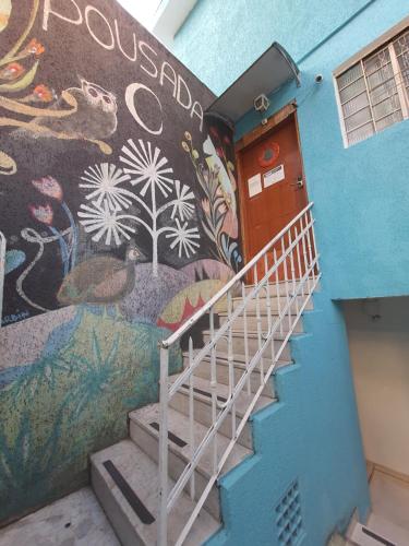 a mural on the side of a building with stairs at Hotel Pousada Clínicas Valente in São Paulo