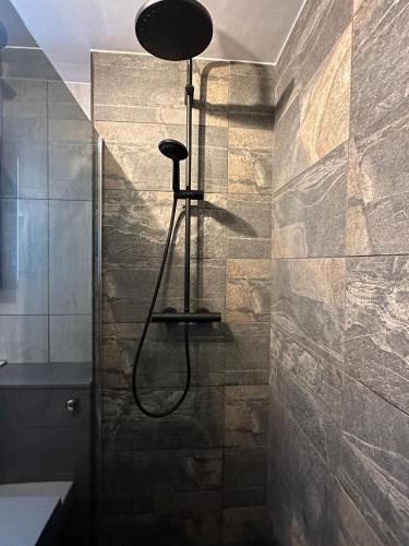 a shower in a bathroom with a stone wall at Two bed apartment with balcony Slough,Windsor,Legoland in Slough