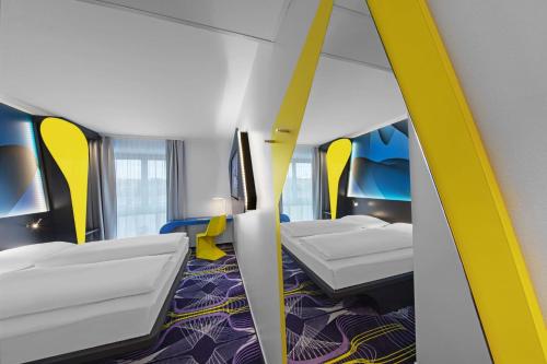 a room with four beds and a mirror at Prize by Radisson, Erfurt City in Erfurt