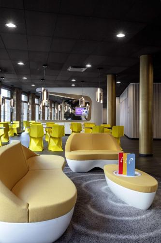 a waiting room with yellow chairs and couches at Prize by Radisson, Erfurt City in Erfurt