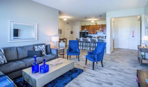sala de estar con sofá y sillas azules en LakeView Penthouse 3 Bedroom In Vista Cay condo en Orlando