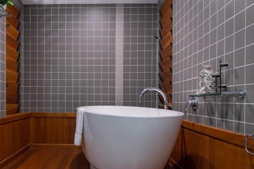 a bath tub in a bathroom with gray tiles at Shutehaven Villa in Shute Harbour