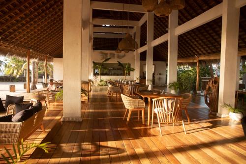 un restaurante con mesa, sillas, mesas y sillas en 81 Palms Resort, en Nembrala