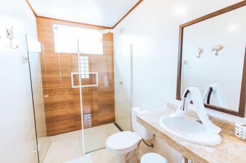 uma casa de banho com um chuveiro, um WC e um lavatório. em VELINN Pousada Praia do Perequê em Ilhabela