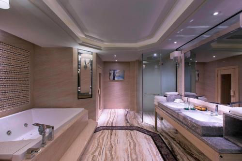 a large bathroom with a tub and a large sink at Sheraton Nanchang Hotel in Nanchang