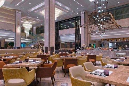 un ristorante con tavoli e sedie e un bar di Sheraton Nanchang Hotel a Nanchang