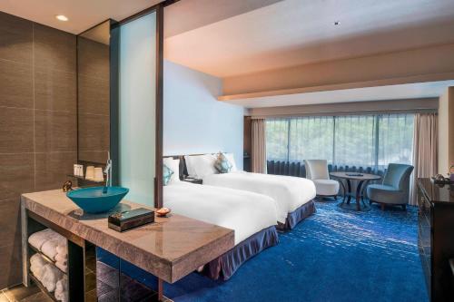 a hotel room with a bed and a large window at Suiran, a Luxury Collection Hotel, Kyoto in Kyoto