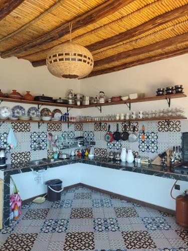 a kitchen with a tiled floor and a ceiling at Dar Aya Dmina in Demina