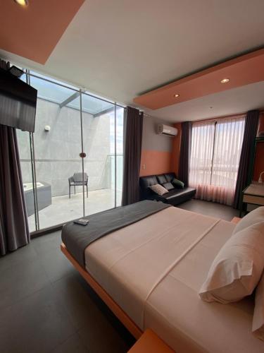1 dormitorio con 1 cama grande y balcón en Hotel G, en Santa Cruz de la Sierra
