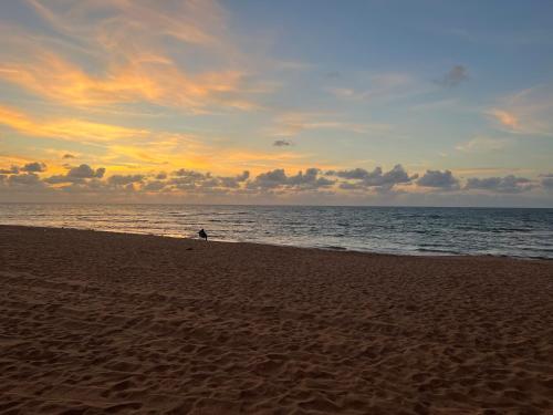 a person walking on the beach at sunset at TAMARIS LES PERLES Rez de Jardin in Tamaris