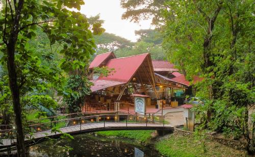 a bridge over a river in front of a building at Cabañas Kin Balam Palenque in Palenque