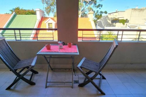 einen Tisch und zwei Stühle auf einem Balkon mit einem Tisch und zwei Tassen in der Unterkunft Location and Lifestyle - 1 bed, 2 bath + parking in Sydney