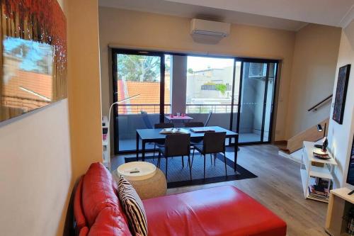 ein Wohnzimmer mit einem roten Sofa und einem Tisch in der Unterkunft Location and Lifestyle - 1 bed, 2 bath + parking in Sydney