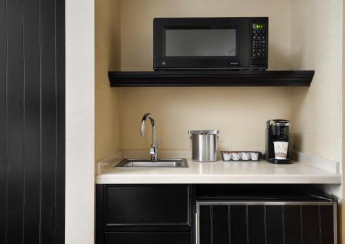 a kitchen with a sink and a microwave at West Inn & Suites in Carlsbad