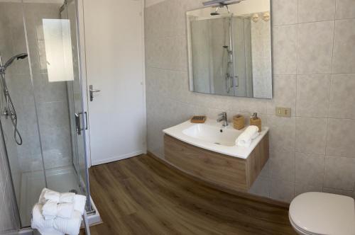 a bathroom with a sink and a shower with a mirror at Appartamento SOLE in Villa Giulia sul Mare in Marausa