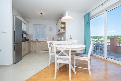 a kitchen and dining room with a table and chairs at Apartments by the sea Sali, Dugi otok - 19880 in Sali