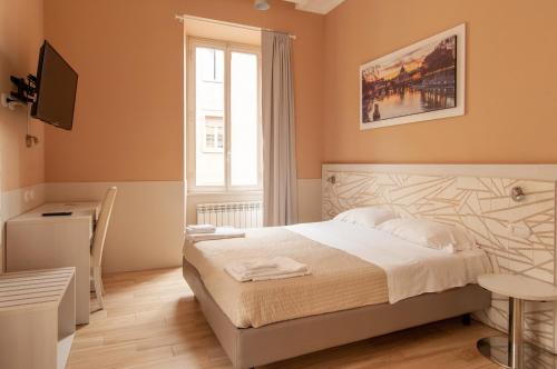 Schlafzimmer mit einem Bett, einem Schreibtisch und einem Fenster in der Unterkunft Domus Porta Angelica in Rom