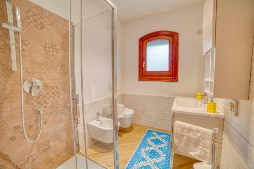 a bathroom with a shower and a toilet and a sink at Villa Hibiscus Stintino in Stintino