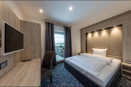 a hotel room with a bed and a large window at Hotel Business Bay das ehemalige Staycation Hotel in Sindelfingen