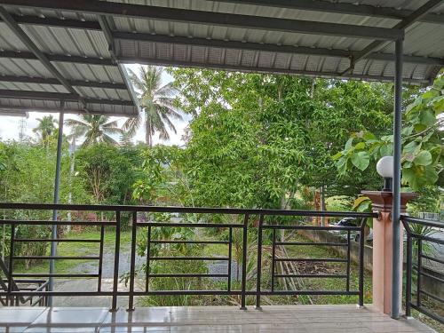 einen Balkon mit einem schwarzen Geländer und Bäumen in der Unterkunft Hidden Gem in Ban Na No