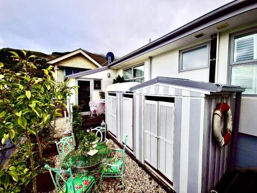 a house with a garden with chairs and a shed at Glamping in Luxury at Little Lytelton Boatique House in  Lyttelton