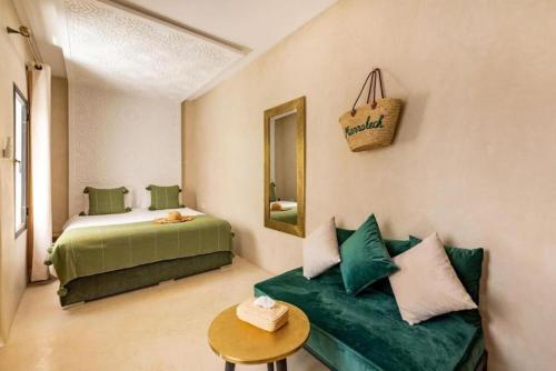 una camera con divano, letto e tavolo di Riad Olika a Marrakech