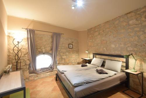 ein Schlafzimmer mit einem Bett und einer Steinmauer in der Unterkunft Luxury VILLA NINI with private pool, bikes, barbecue and much more in Poreč