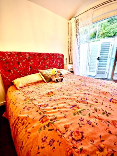 a bedroom with a large bed with a floweridered comforter at Glamping in Luxury at Little Lytelton Boatique House in  Lyttelton