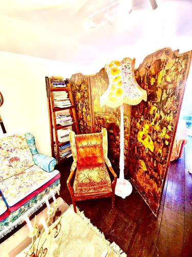a living room with a chair and a lamp at Glamping in Luxury at Little Lytelton Boatique House in  Lyttelton