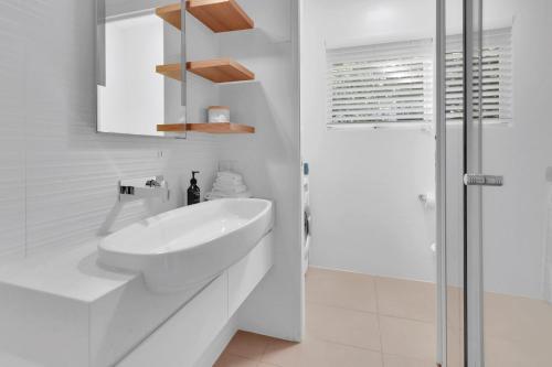 un bagno bianco con lavandino e doccia di The Cove Noosa - Apartment 21 a Noosa Heads