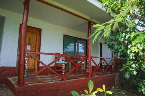 a front porch of a house with a wooden door at Cabañas MANA NUI INN in Hanga Roa