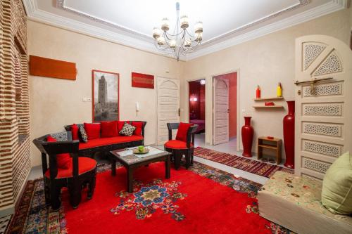 a living room with red furniture and a red rug at Riad Appart Arwa in Marrakech