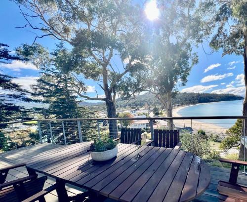 a wooden table on a deck with a view of the water at Beach House, Stunning Views of Kingston Beach in Kingston Beach