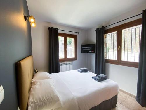 a bedroom with a large white bed and two windows at Moderno Y Rústico En Ransol 6pax in Canillo