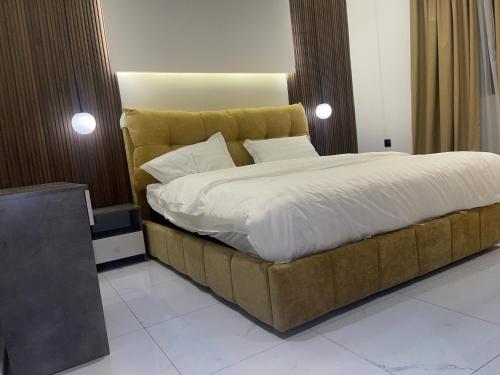 1 dormitorio con 1 cama grande con sábanas blancas en فلل بيات الفيصل Bayat Al Faisal Villas, en Baljursi