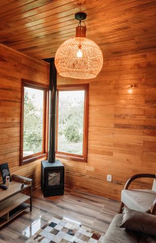 a room with a stove in a wooden house at Pousada Vila Felicita in São Valentim