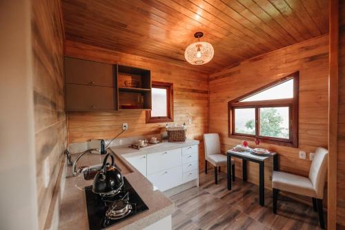 a kitchen with wooden walls and wooden flooring at Pousada Vila Felicita in São Valentim