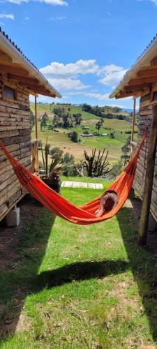 an orange hammock in front of a house at El Refugio del Santo in El Lindero