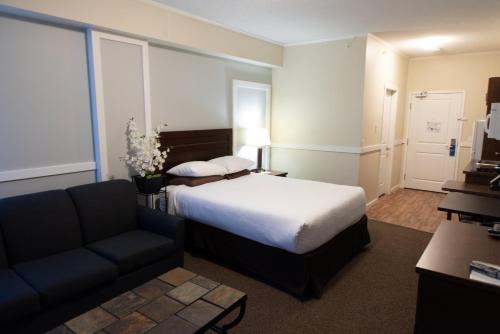a hotel room with a bed and a couch at Days Inn by Wyndham Lamont in Lamont