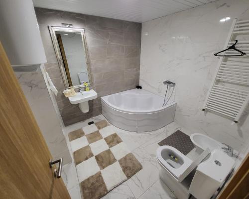 a bathroom with a tub and a sink and a toilet at Mr.-Legend's Penthouse in Skopje